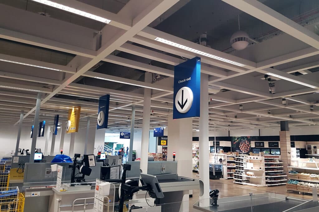 Grey fabric ducts in the ceiling above retail checkout tills