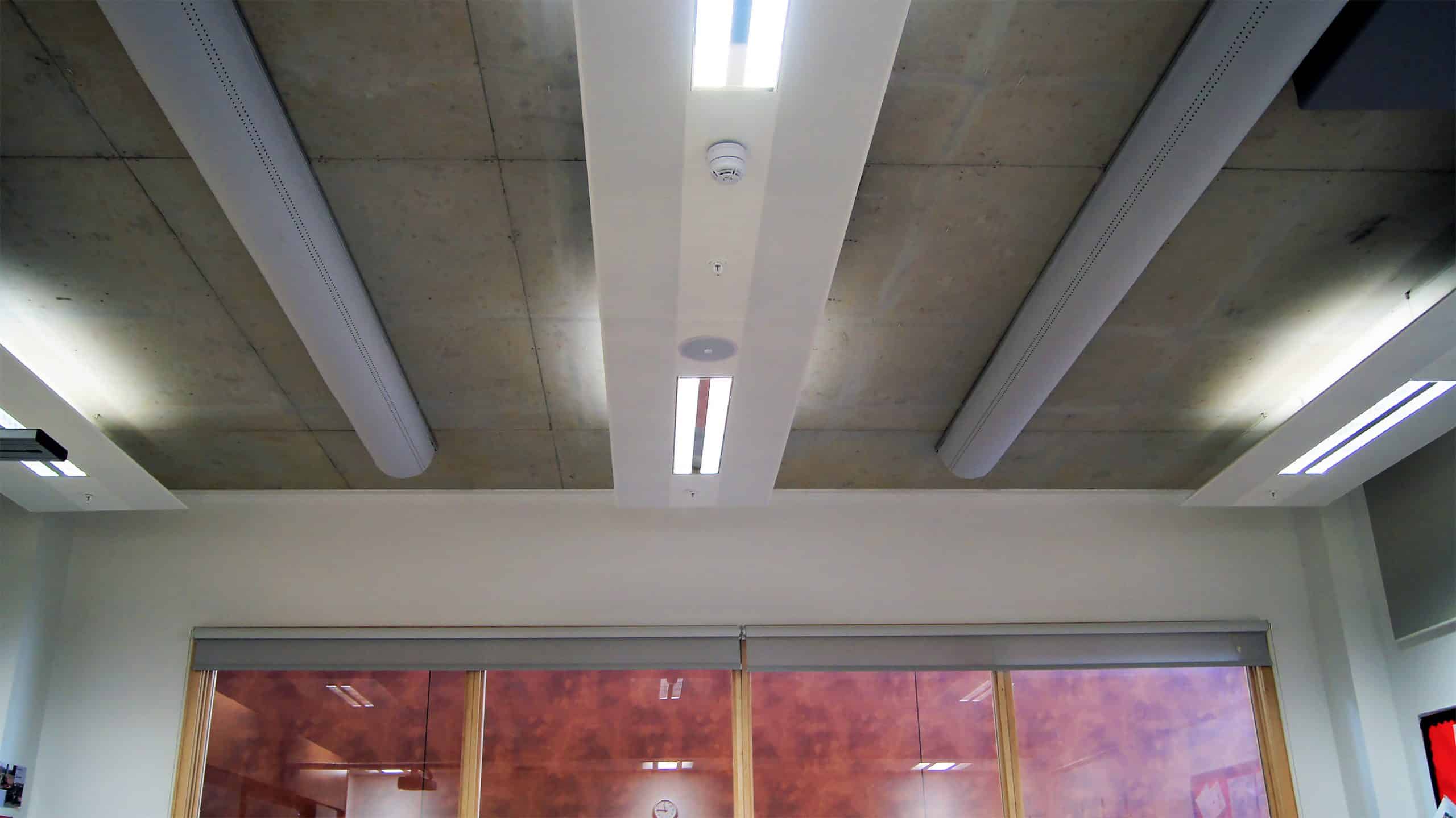 Half round fabric ducts installed on exposed concrete ceiling